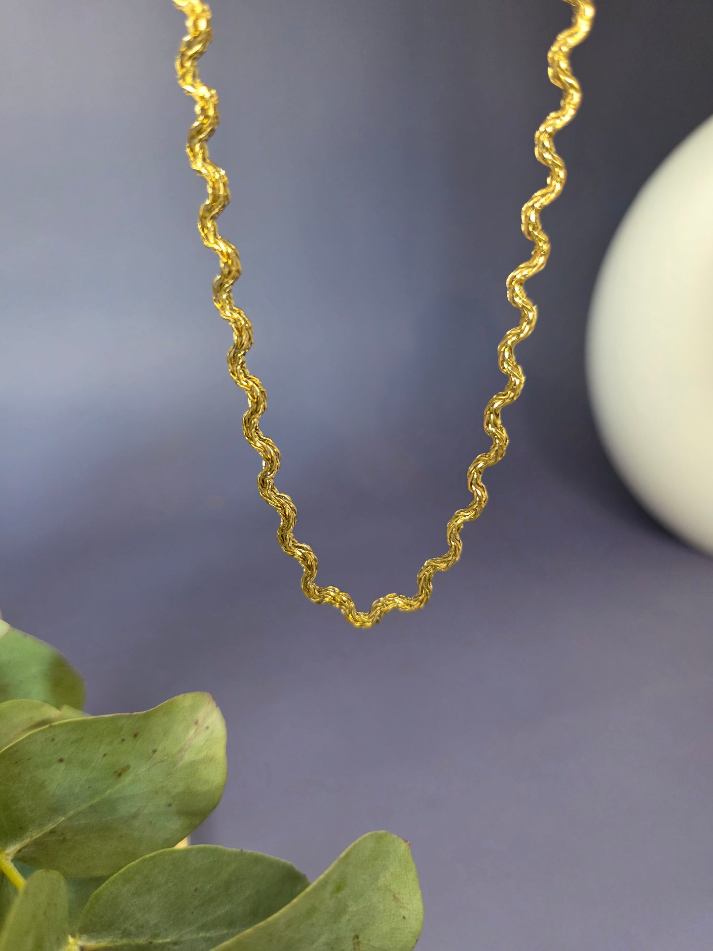 Model view of the gold-plated Dorian Chain necklace, showing how the wavy-link choker rests gracefully on a beige fabric bust. The chain is $41 \text{ cm}$ long with a $5 \text{ cm}$ extender.