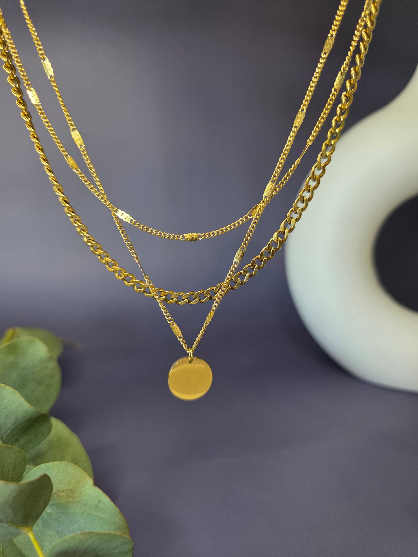 The Luminous Trio gold necklace shown floating to highlight the separate chain textures. Tarnish-resistant link and satellite chains with a shared 5cm extender - My Silver Lining.