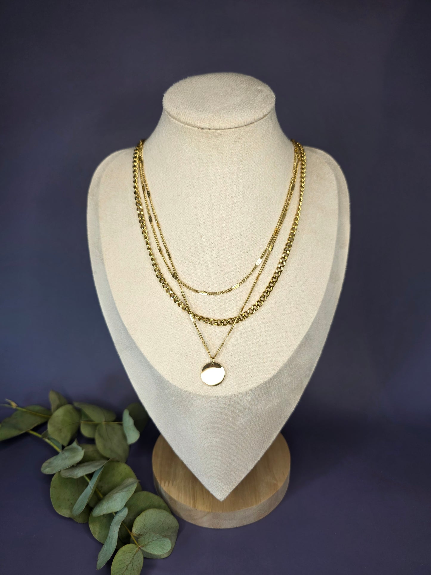 The Luminous Trio layered necklace set styled on a white jewelry bust. This gold plated 3-chain set includes a curb link and disc pendant in waterproof stainless steel - My Silver Lining.