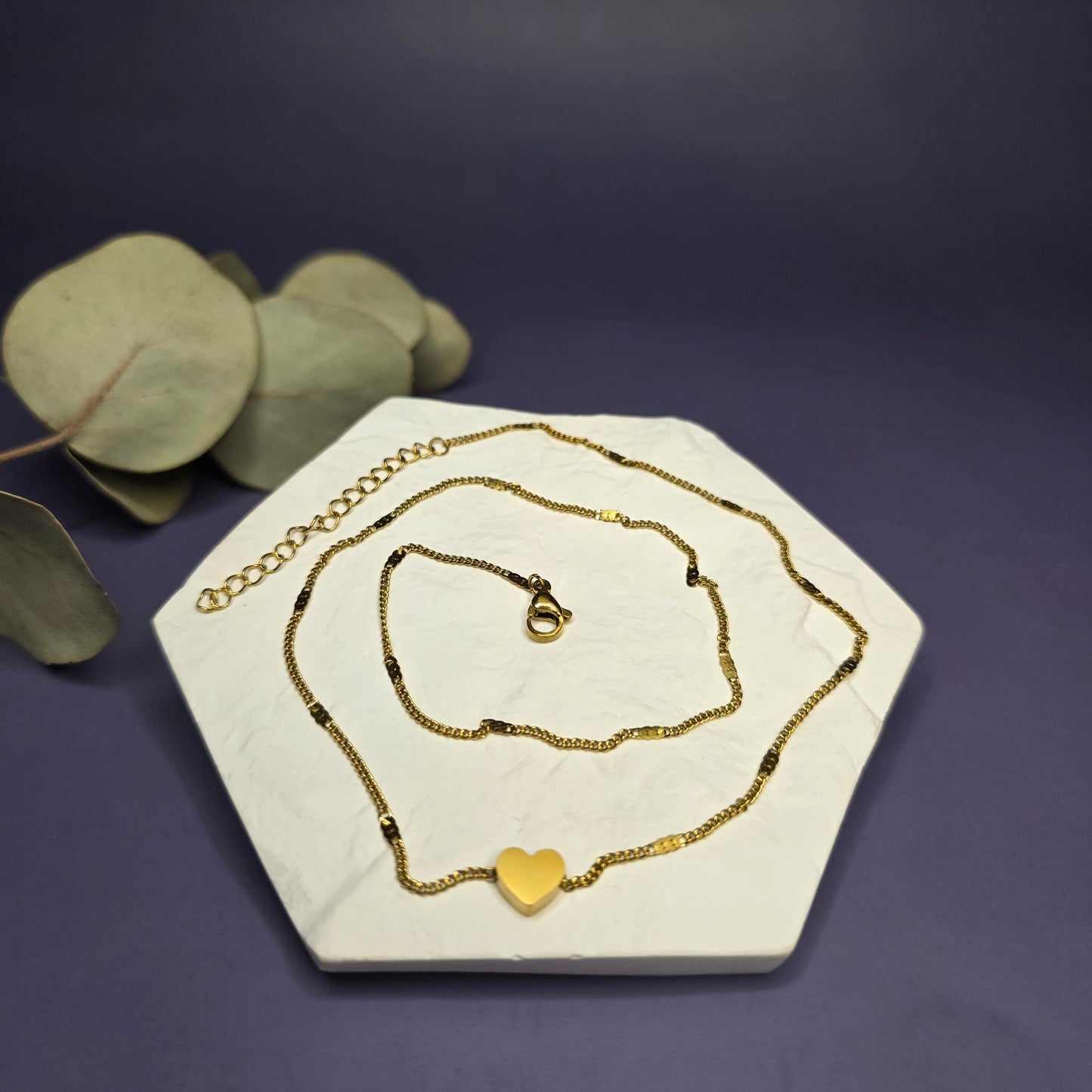 Optimized flat lay of the Tiny Heart Necklace, showcasing the 18K gold plated brushed link chain and 8mm heart — My Silver Lining.
