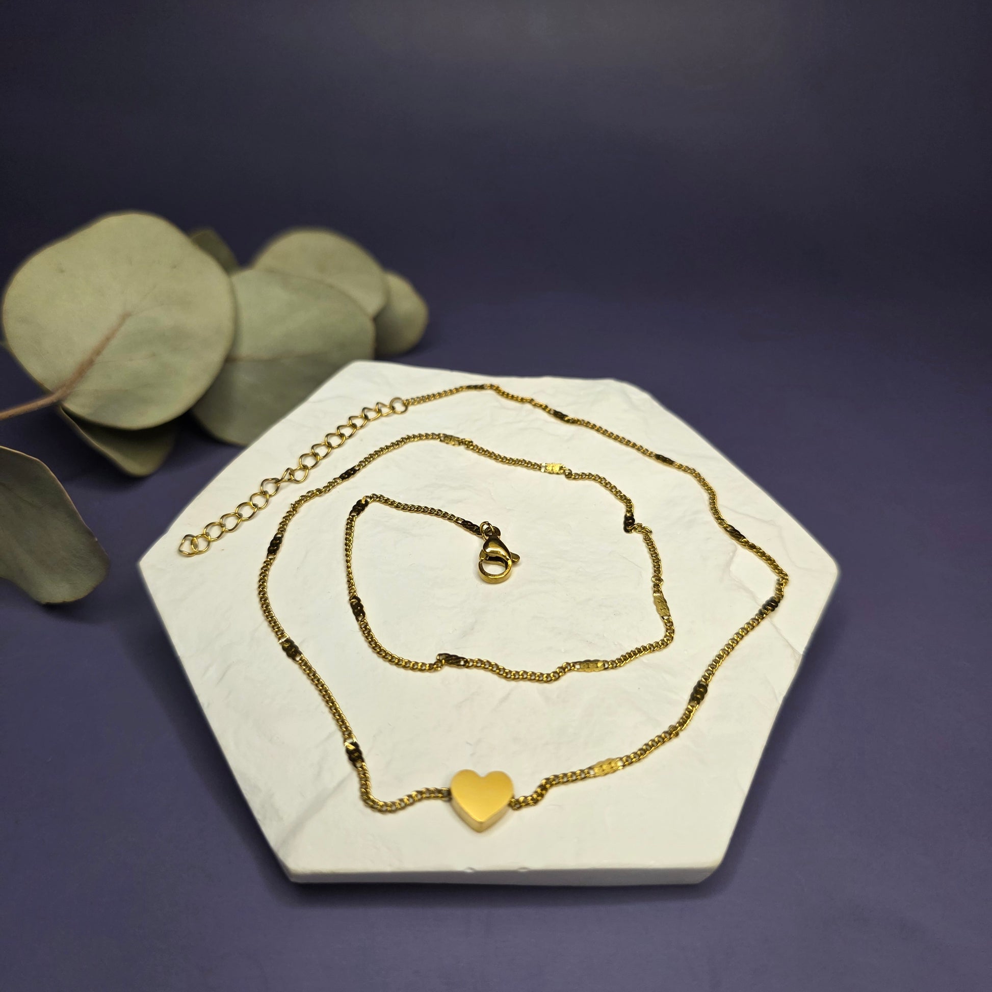 Optimized flat lay of the Tiny Heart Necklace, showcasing the 18K gold plated brushed link chain and 8mm heart — My Silver Lining.