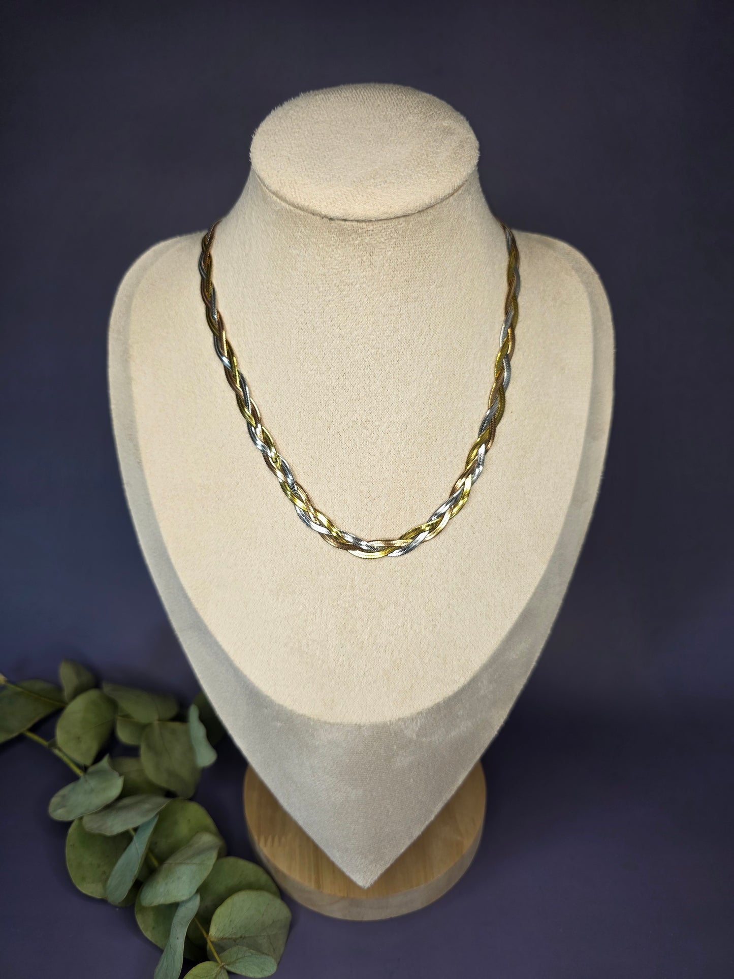Trinity Braid necklace displayed on a tan jewelry bust. A luxurious 45 cm tri-tone braided chain that beautifully weaves together gold, silver, and rose gold tones - My Silver Lining.