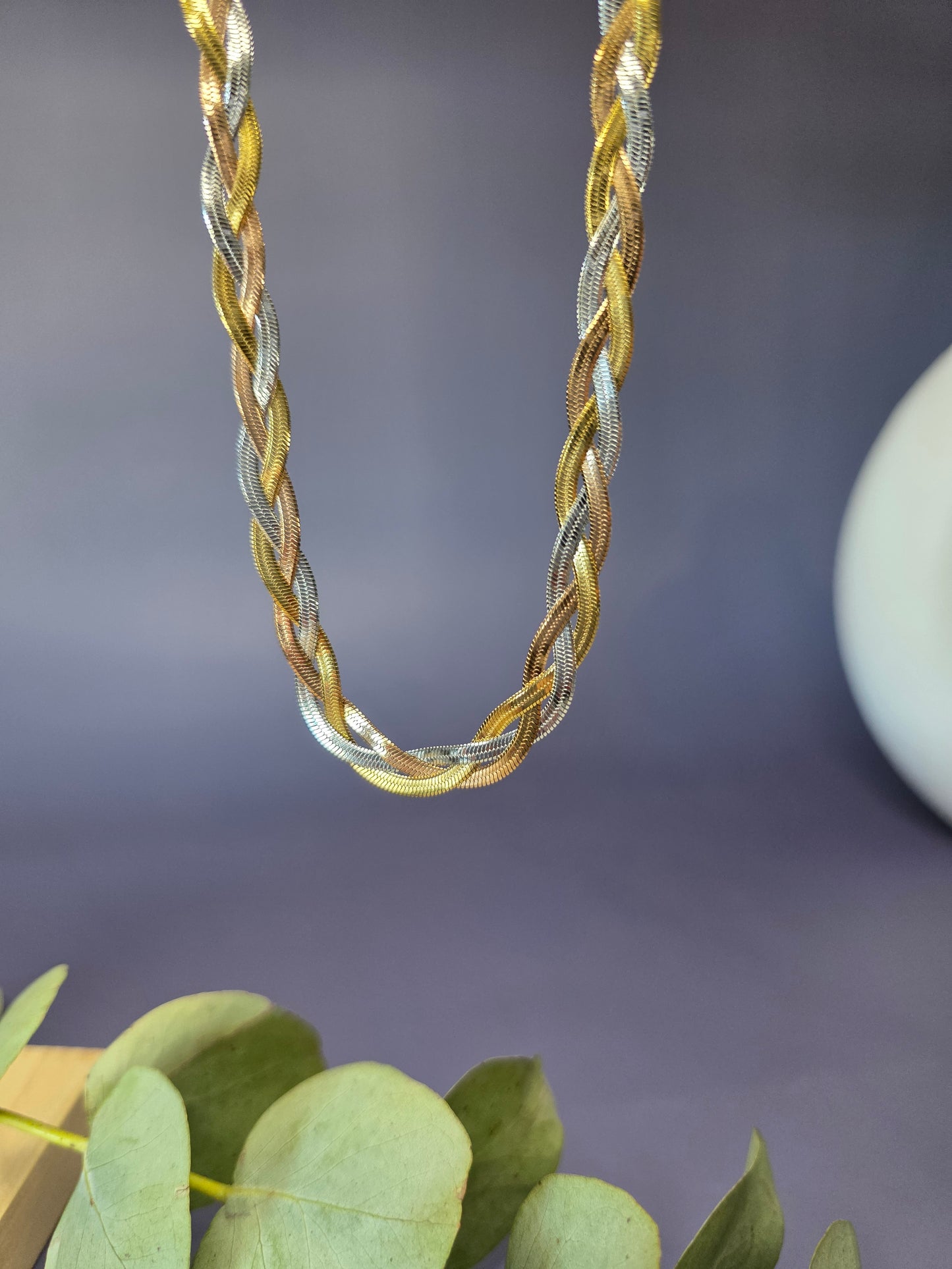 Trinity Braid necklace showcasing the intricate weave of gold, silver, and rose gold strands. This waterproof tri-tone stainless steel chain offers a multi-dimensional shimmer - My Silver Lining.