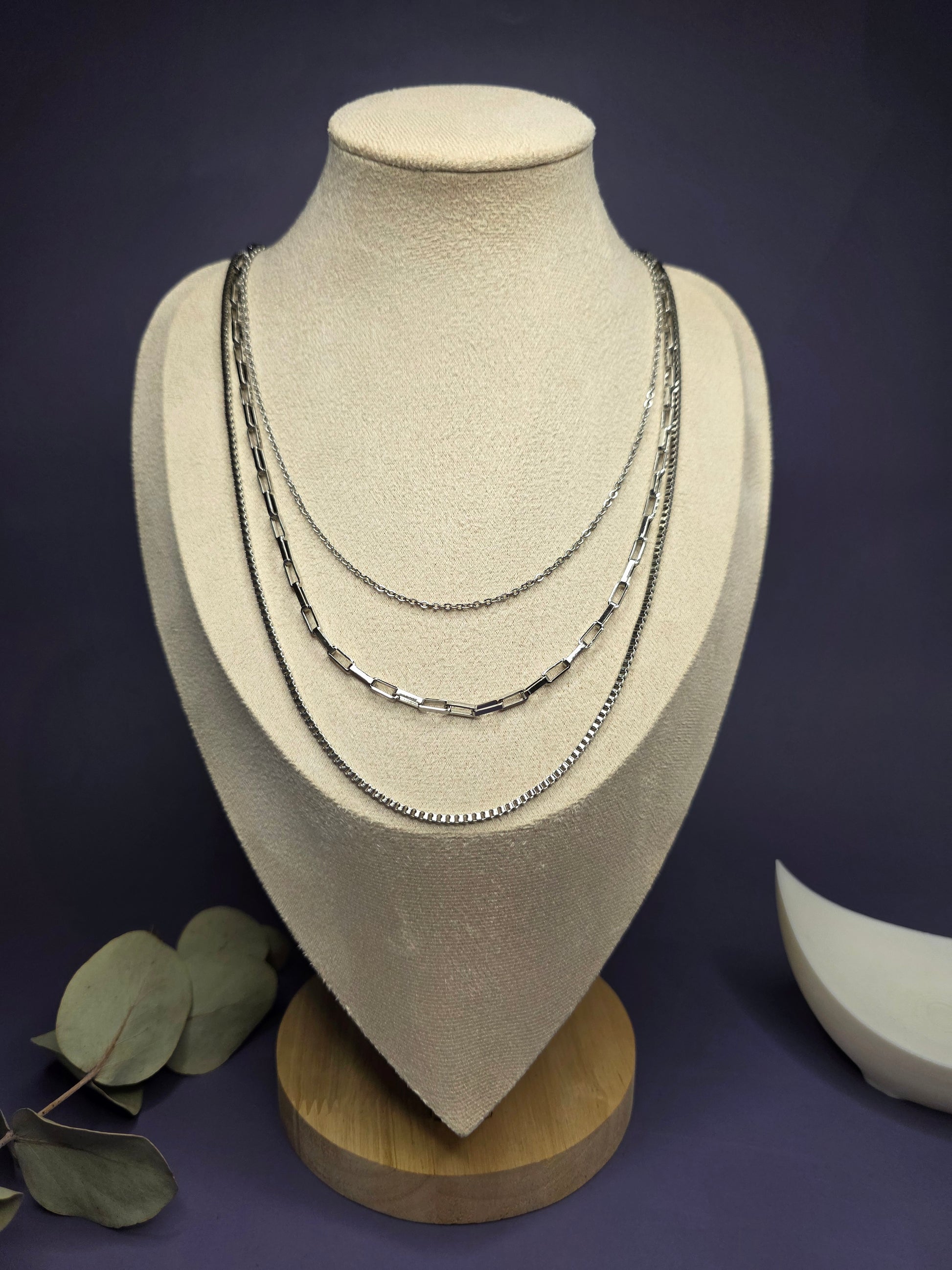 Optimized view of the Trinity Silver Layer necklace on a jewelry bust, showcasing the three graduated lengths in polished stainless steel — My Silver Lining.