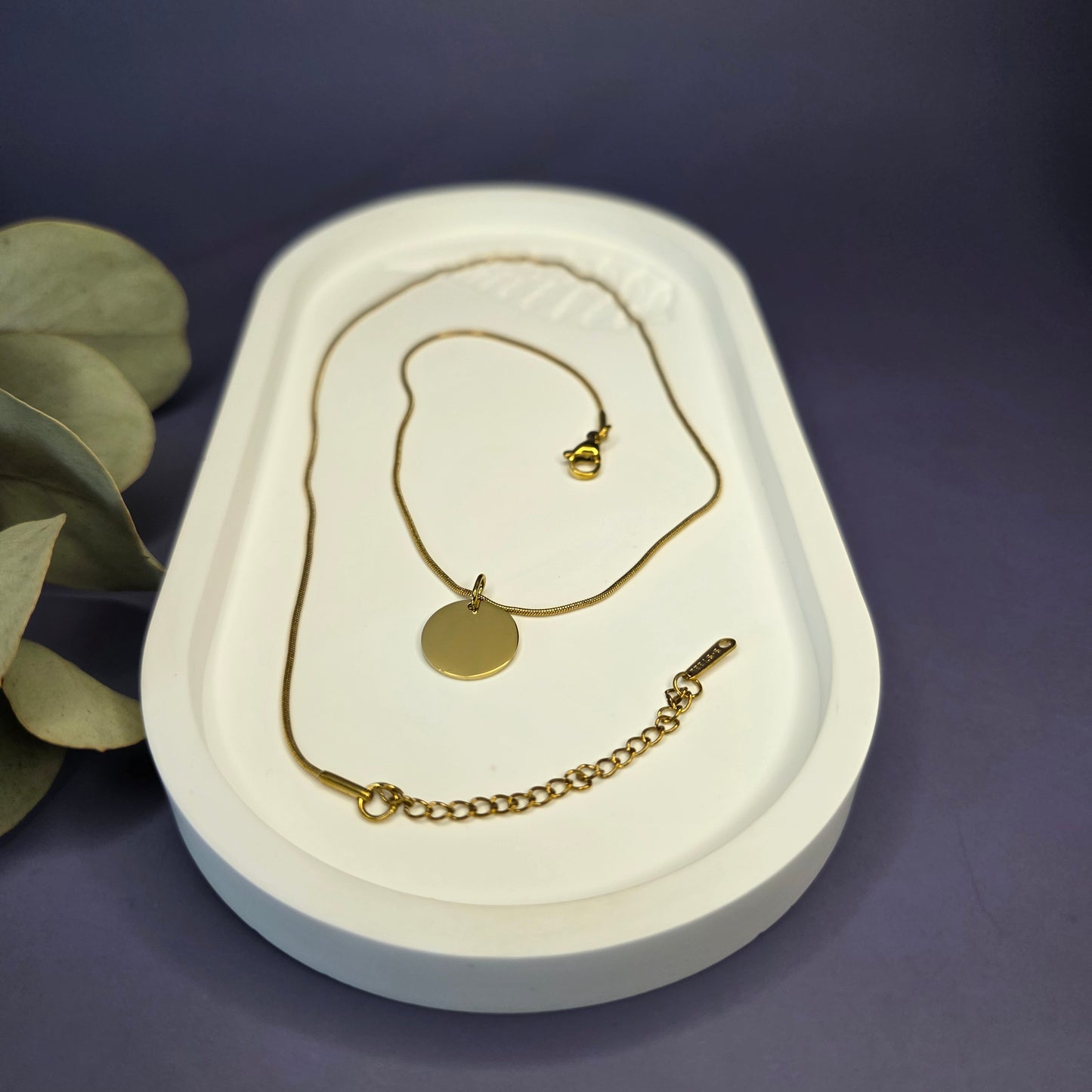 Close-up of the Golden Mamma Bear necklace on a white oval tray, highlighting the 0.9mm snake chain and adjustable extender — My Silver Lining.