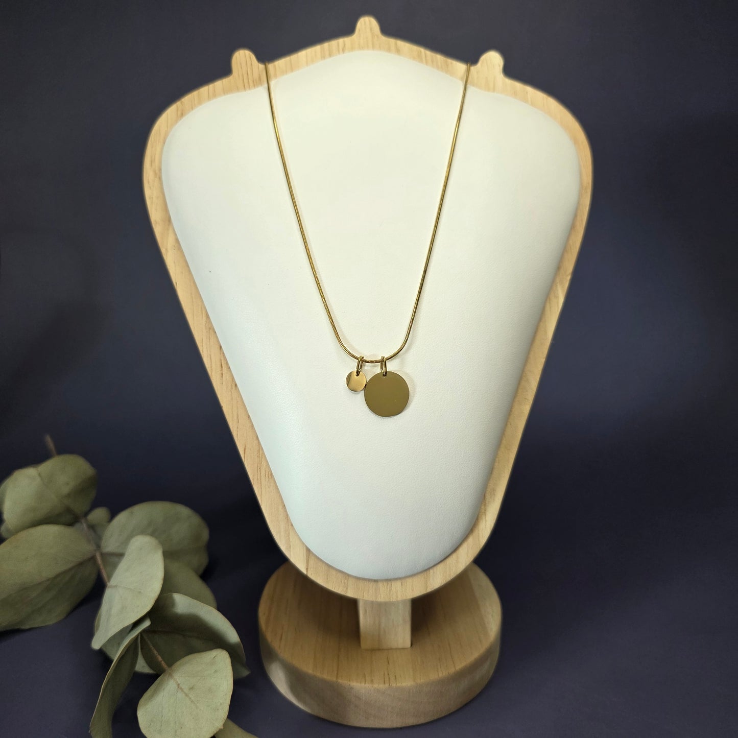 Front view of the Golden Mamma Bear necklace on a jewelry bust, showcasing the full variant with four smaller discs — My Silver Lining.