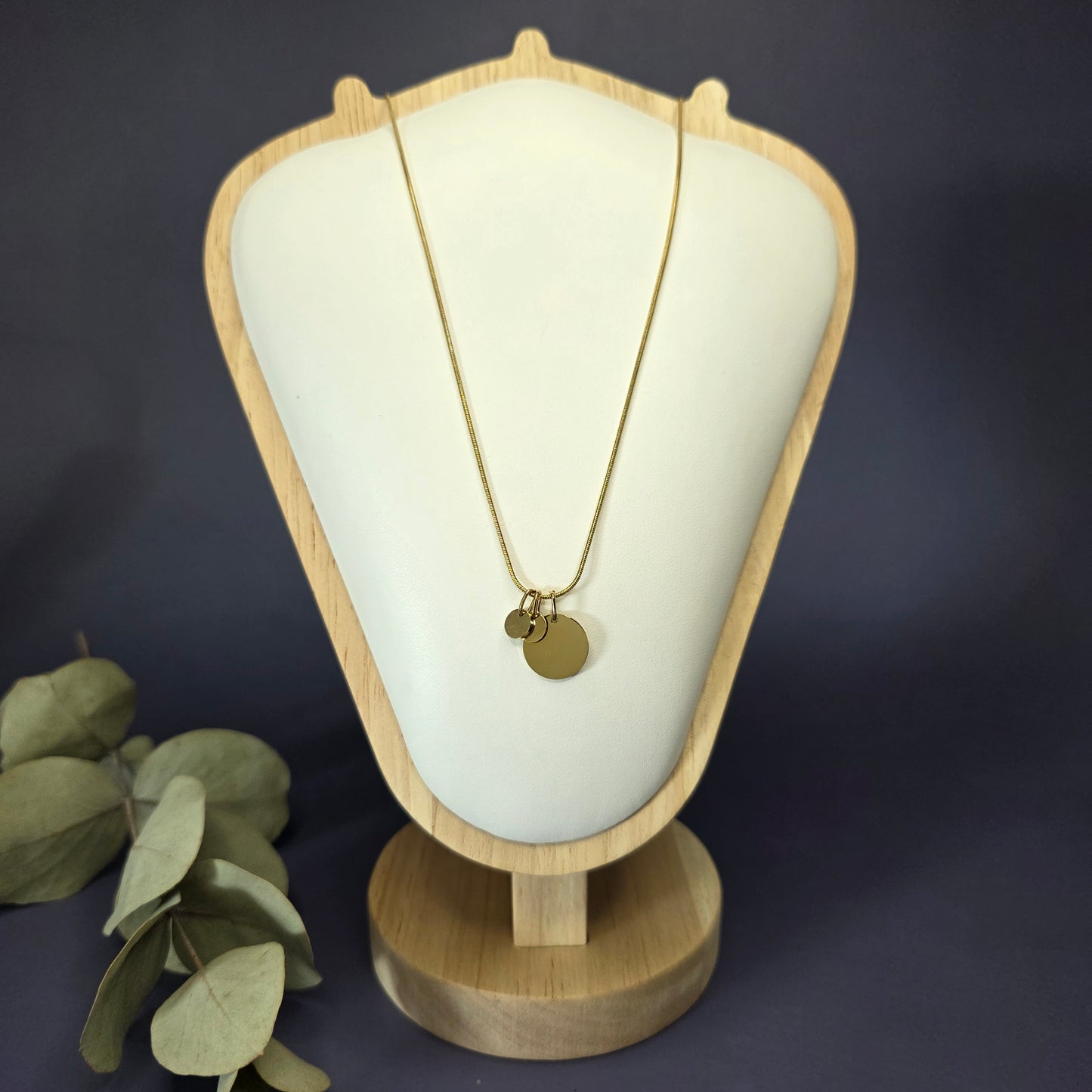Front view of the Golden Mamma Bear necklace on a jewelry bust, showcasing the full variant with two smaller discs — My Silver Lining.