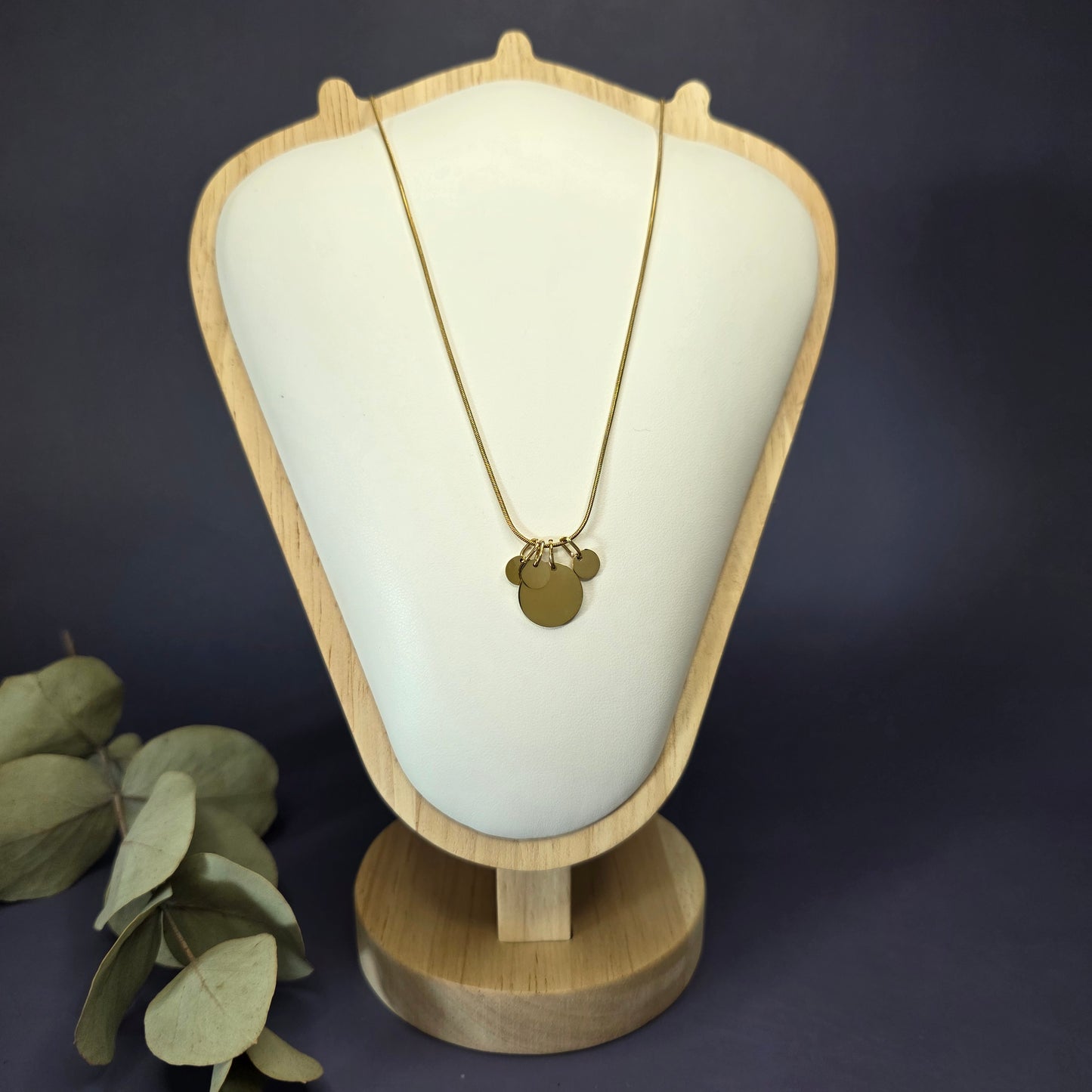 Front view of the Golden Mamma Bear necklace on a jewelry bust, showcasing the full variant with four smaller discs — My Silver Lining.