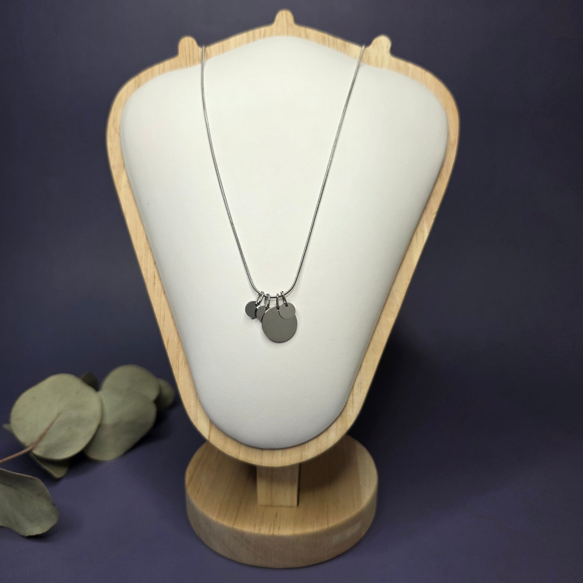 Front view of the Siler Mamma Bear necklace on a jewelry bust, showcasing the full variant with three smaller discs — My Silver Lining.