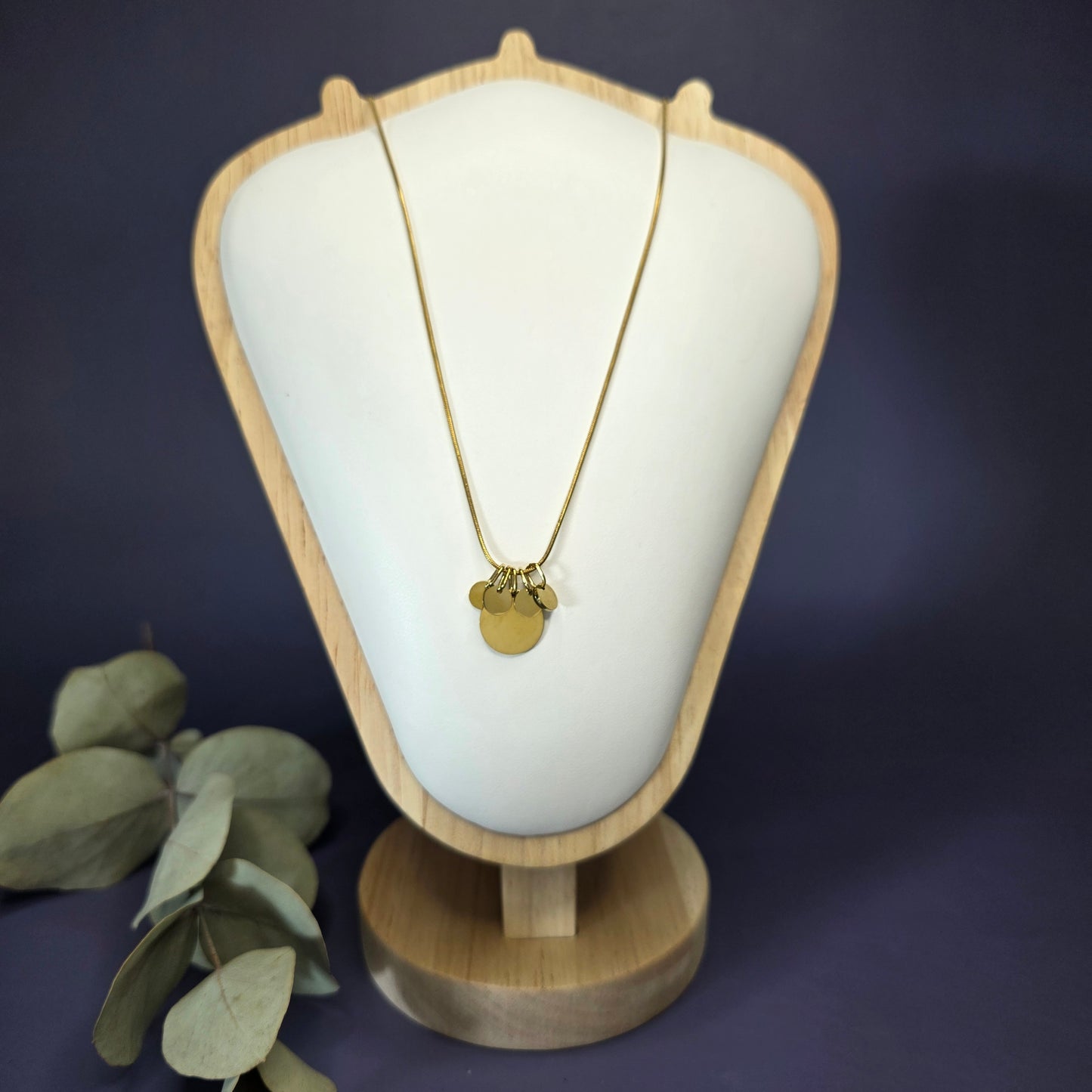 Front view of the Golden Mamma Bear necklace on a jewelry bust, showcasing the full variant with four smaller discs — My Silver Lining.