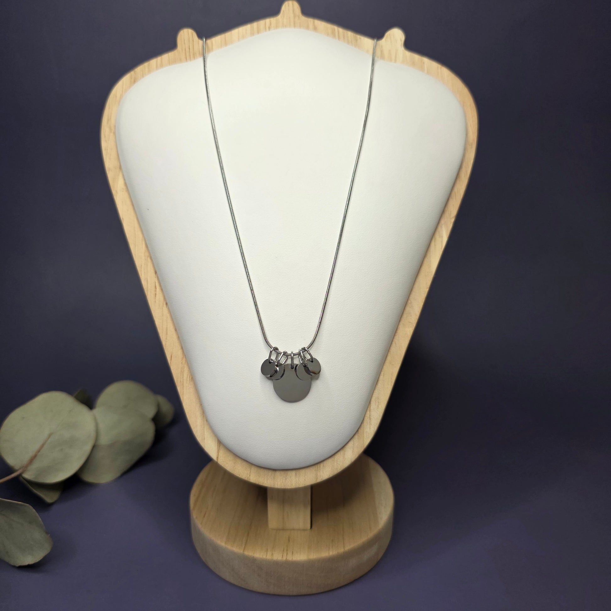 Front view of the Siler Mamma Bear necklace on a jewelry bust, showcasing the full variant with four smaller discs — My Silver Lining.